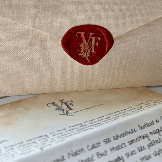 A red wax seal stamped with the initials "VF" and a botanical motif, securing a textured beige envelope. Below the envelope lies a vintage-style letter marked “The Property of Victoria Fraser,” with elegant handwriting and a faintly aged paper effect.