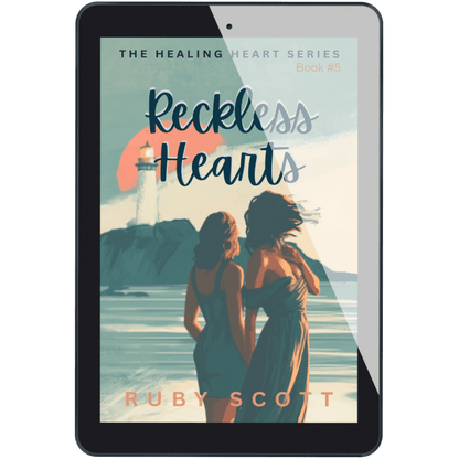 A tablet device displaying the book cover for 'Reckless Hearts, Book #5' by Ruby Scott. The cover art features an illustration of two women standing by the sea with a lighthouse and sunset in the background.